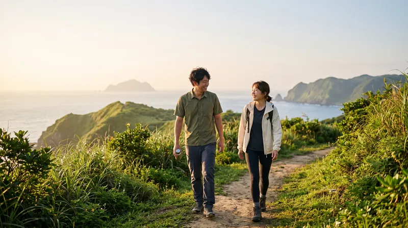 海沿いの山道を並んで歩き、話しながら笑っている二人